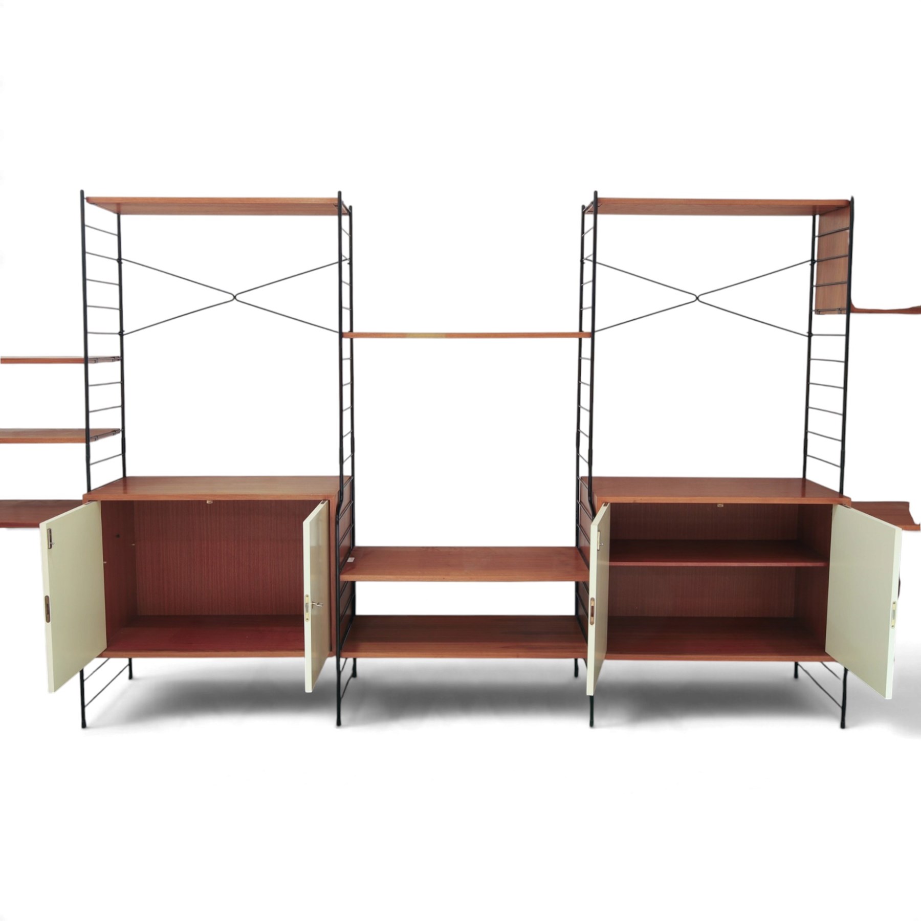 WHB - 'Ladderax' 1960s German modular shelving wall unit, comprising two teak cabinets with white doors, a further fall front teak cabinet with white front, a drawer section with three drawers with recessed handles, multiple shelving sections, raised on metal ladder frames, with further spare sections

Cabinet units: H 47cm, D 36cm, W 71cm
Fall front unit: H 40cm, D 26cm, W 71cm
Shelve widths: 50cm, 71cm 
Shelve depths: 26cm, 36cm