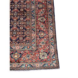 Persian Heratti indigo ground carpet, the busy field decorated with repeating floral pattern Heratti motifs, scrolling leafy branches and palmettes to the crimson ground border, within foliate pattern guard stripes 
