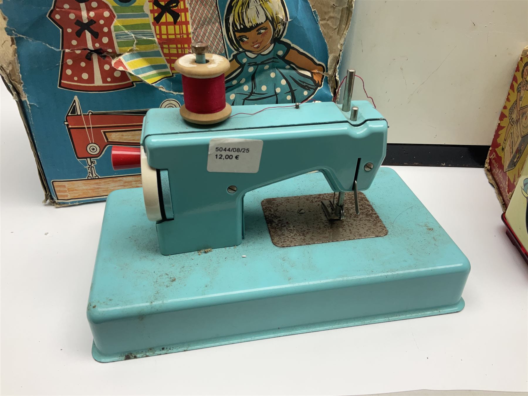 Six toy kitchen appliances - Casdon battery operated cooker; Mettoy Hoover washer; Chad Valley Hoovermatic washer; Wells Brimtoy tin-plate clockwork washer; and two Morphy Richards irons; together with a continental child's Regina sewing machine; all boxed (7)