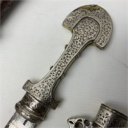 Moroccan jambiya dagger with 24.5cm plain curved blade stamped LONDON to the ricasso area, the hilt and scabbard overlaid with plain sheet brass to the back and ornate silver coloured metal to the front; waisted grip and arched pommel; two pyramid mounts to the scabbard L41cm overall; large billhook with curving blade and stacked leather washer grip; and a reproduction halberd blade (3)