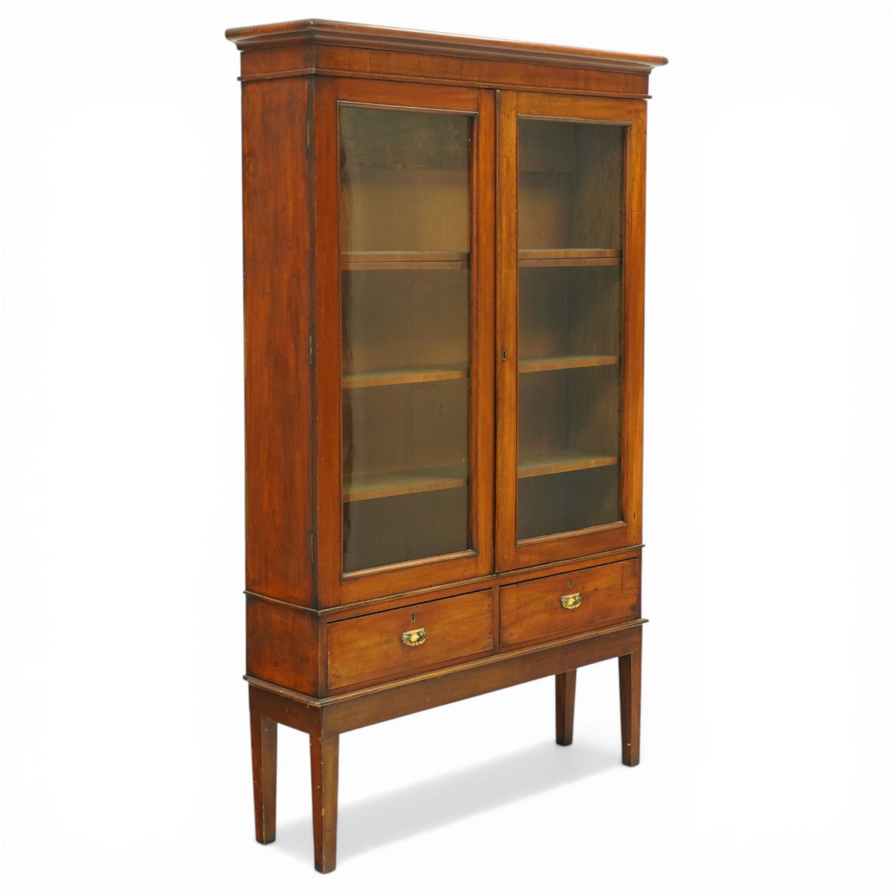 19th century mahogany enclosed bookcase on stand, projecting cornice and banded frieze over two glazed doors enclosing four adjustable shelves, fitted with two drawers to base, on square tapering supports