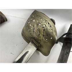 George V British Army 1897 pattern officers sword with plain 82cm fullered steel blade, pierced  basket hilt with George V cypher and wire bound leather grip with chequered backstrap; in leather covered field service scabbard L101cm overall; and another officer's sword in relic condition lacking scabbard (2)