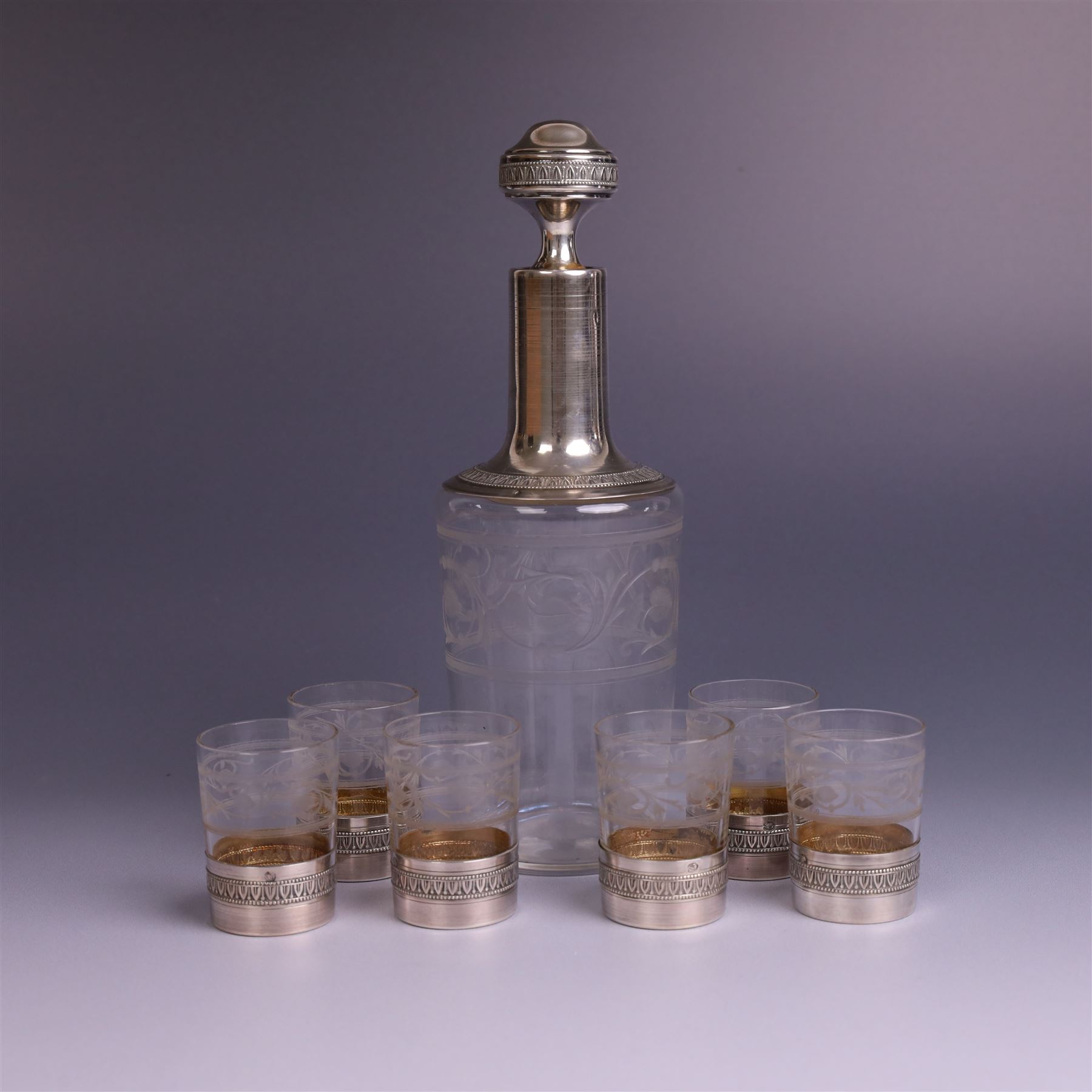 French silver mounted glass decanter and shot glass set, the decanter with silver covered stopper, removable silver collar, and etched decoration to glass body, the six silver mounted glasses each with etched decoration, silver stamped with Minerva's head, decanter H 21cm