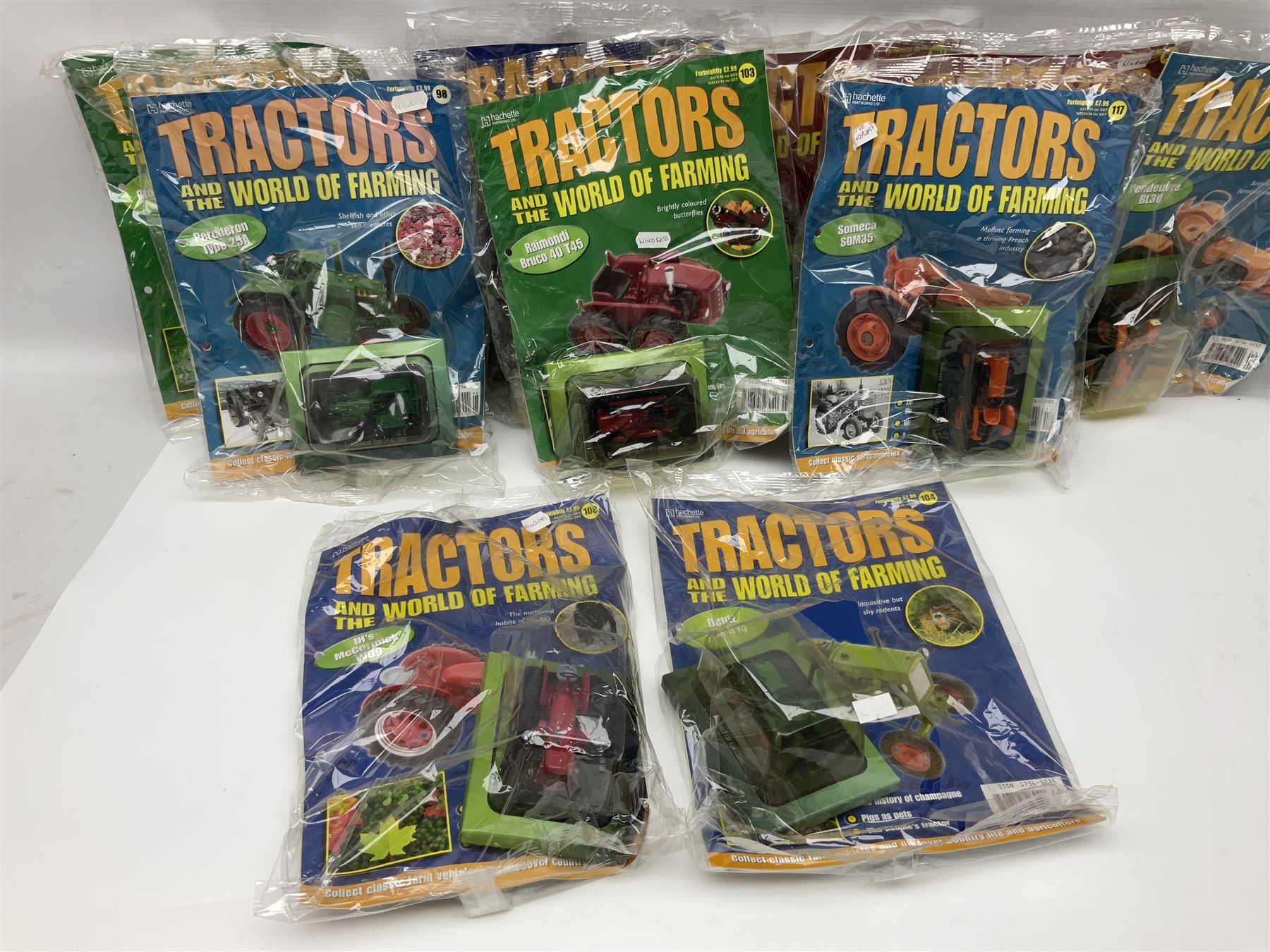 Eighteen issues of Tractors and The World of Farming magazine, together with sixty diecast tractors, all in original packaging, in three boxes 