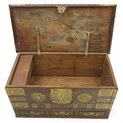 Early 20th century brass-mounted hardwood chest, the hinged top and front richly decorated with applied and studded brass panels and pierced lock escutcheon, revealing a candle box, reinforced with brass corner mounts