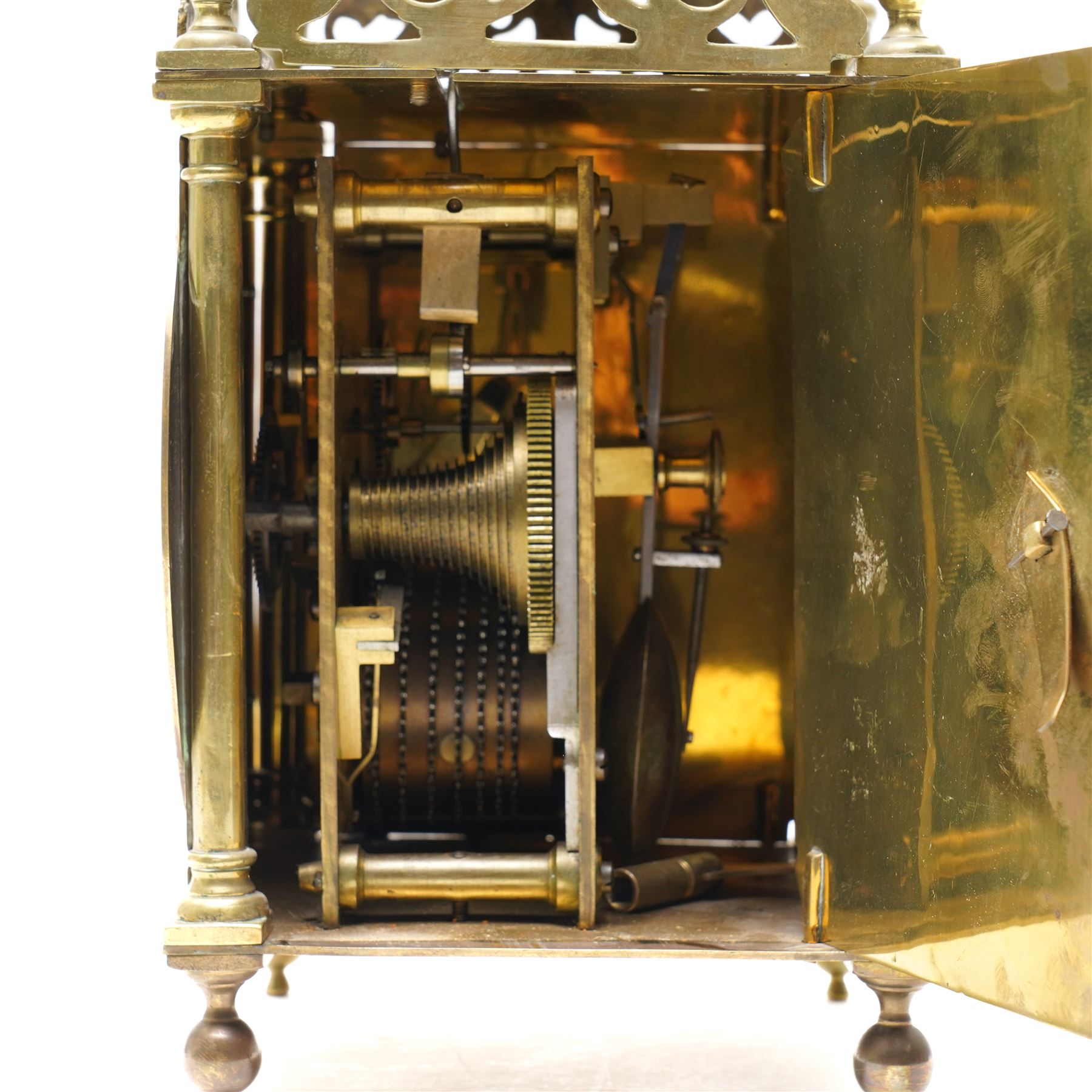 English-17th-century style replica 8-day lantern clock with a suspended bell and turned finials, with three ornate frets to the front and sides and opening side and rear doors, with an engraved dial centre and formerly silvered chapter with engraved Roman numerals, inner quarter hour track and period steel hands, dial engraved 