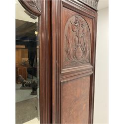 Late Victorian walnut triple wardrobe, projecting cornice over a acanthus carved frieze, central mirror glazed door flanked by two panelled doors relief carved with foliate urns, plinth base