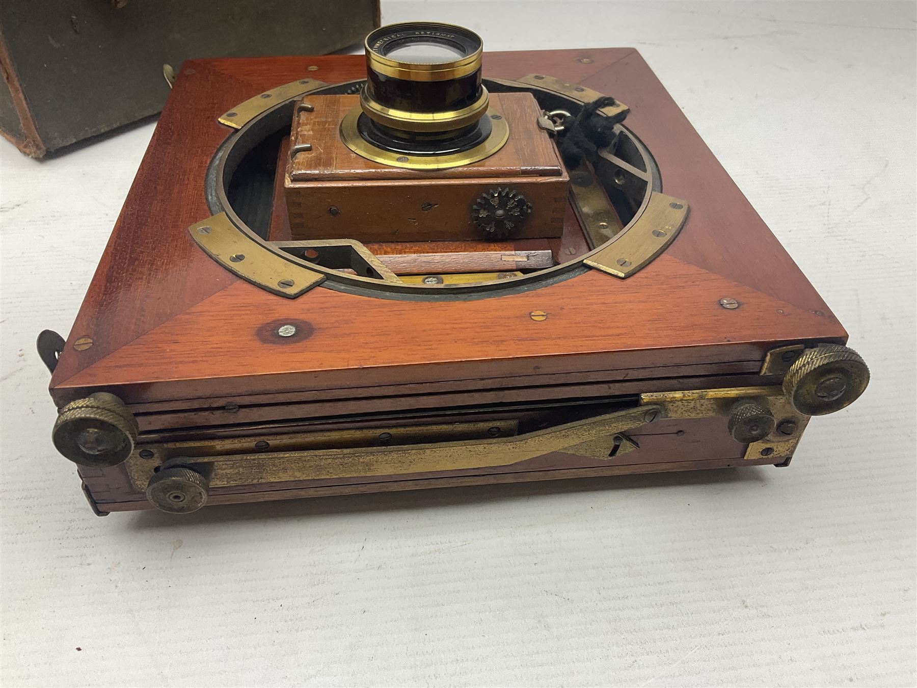 Folding plate camera in mahogany and lacquered brass, with Rapid Symmetrical Reetigmat len and two dark slides in canvas case