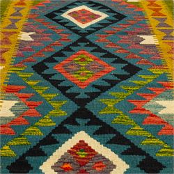 Maimana kilim flatweave runner, central field features a large bold nested diamond motif and stylized geometric lozenge patterns on olive purple, blue, and green tone ground, border stripe in teal ground, and fringe