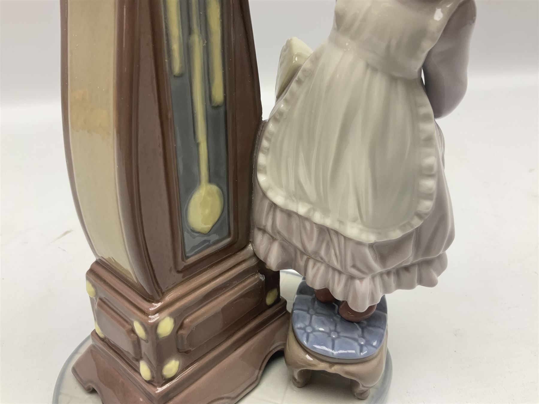 Lladro figure, Bedtime, modelled as a young girl reaching for her pet cat upon grandfather clock, sculpted by Vincente Martinez, with original box, no 5347, year issued 1986, year retired 1998, H28cm