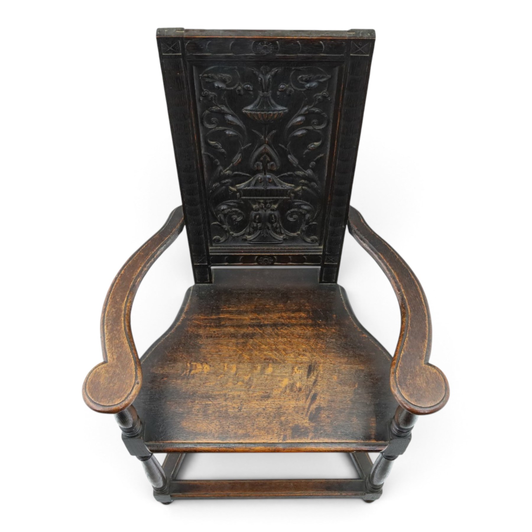 17th design century carved oak hall chair, carved back with urn and foliate details, shaped seat and arms, raised on turned supports united by stretchers