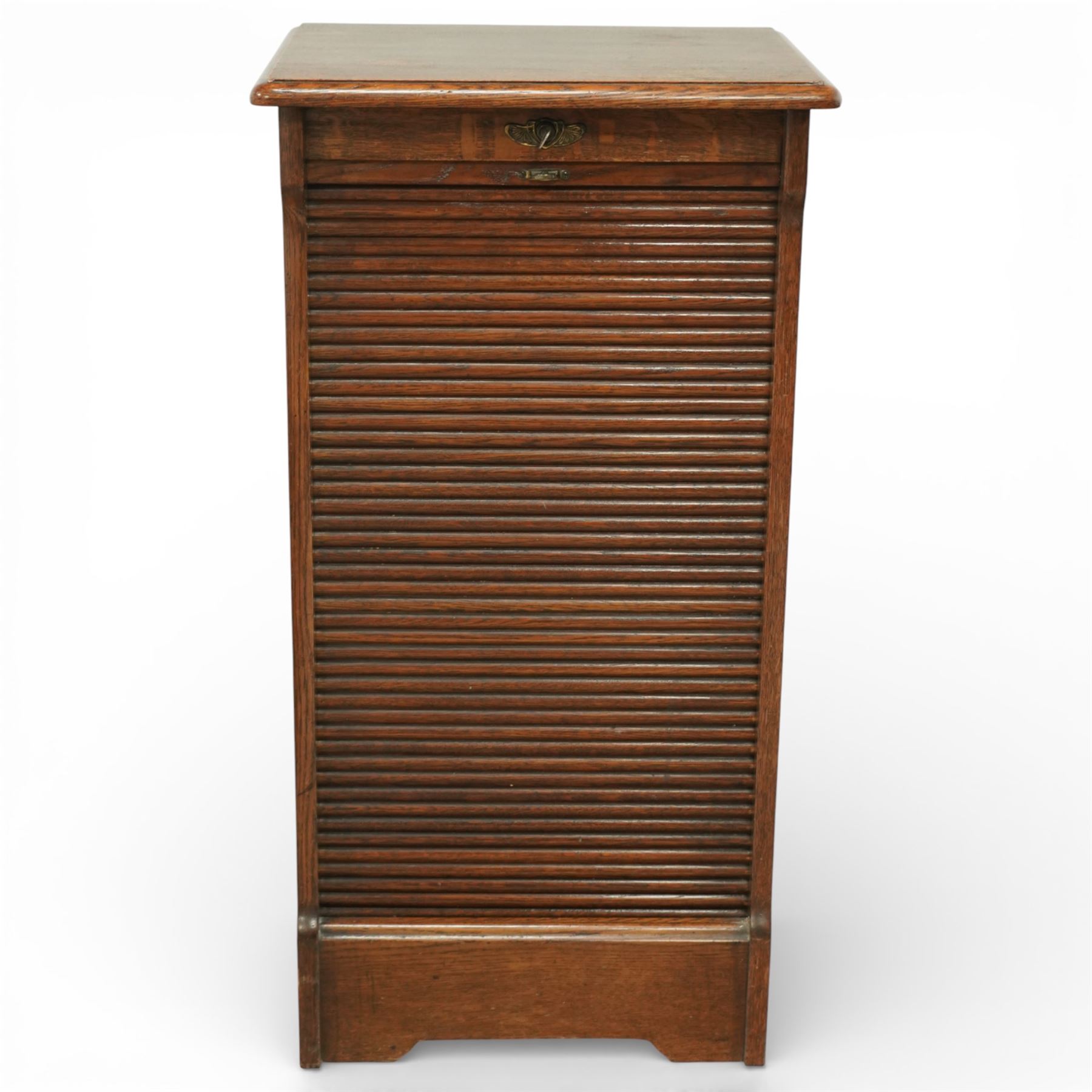 Early 20th century oak filing cabinet, the rectangular top with moulded edge above a tambour shutter enclosing a fitted interior with eleven shaped filing shelves, the sides with shaped uprights, raised on a plinth base