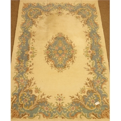  Indian washed woolen ivory ground rug with blue scrolling border and central medallion, 270cm x 172cm  