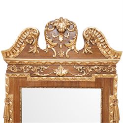 20th-century ornate gilt and mahogany Chippendale style wall mirror, the wooden gilt-edged frame with applied scrollwork with foliate motifs, drape, and tassel decoration 