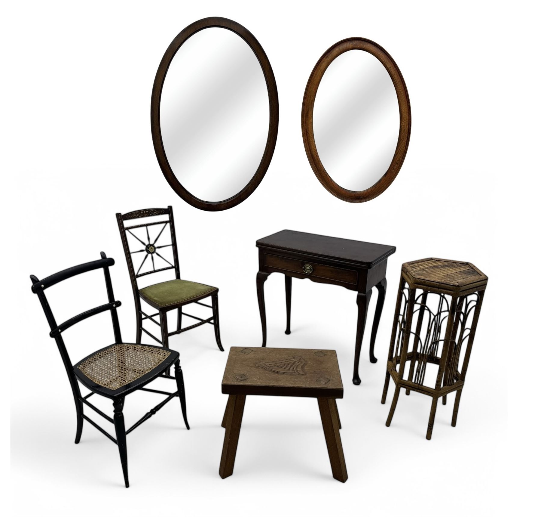 Late 19th century black-painted cane seat chair; early 20th century radial spindle-back chair with green upholstery; early 20th century mahogany single-drawer side table; mid-20th century carved wooden stool with harp motif; early 20th century hexagonal bamboo stand; two oval mirrors (7)
