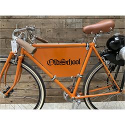 Fully restored vintage advertising bicycle with 2 stroke petrol engine, orange frame, tan leather seat