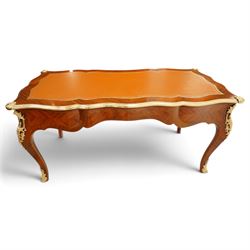 Baggio Anciens Meubles - Italian Louis XV style kingwood and gilt metal mounted bureau plat or writing desk, the shaped rectangular top with inset leather writing surface with gilt metal edge, above three shaped frieze drawers with gilt metal handles, raised on cabriole supports with gilt cartouche mounts to the knees and scroll feet