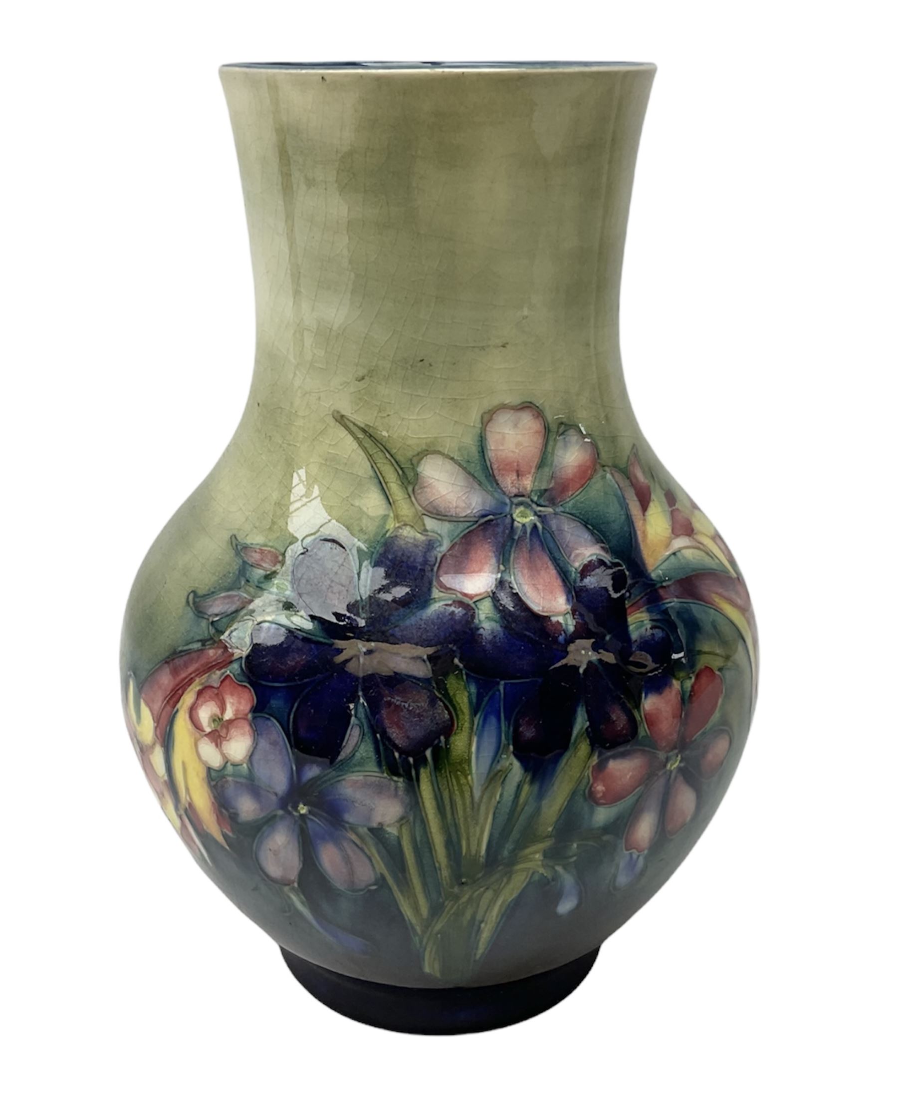Moorcroft vase of baluster form decorated in the Spring Flowers pattern upon a merging green and blue ground, with impressed and painted marks beneath, H22.5cm