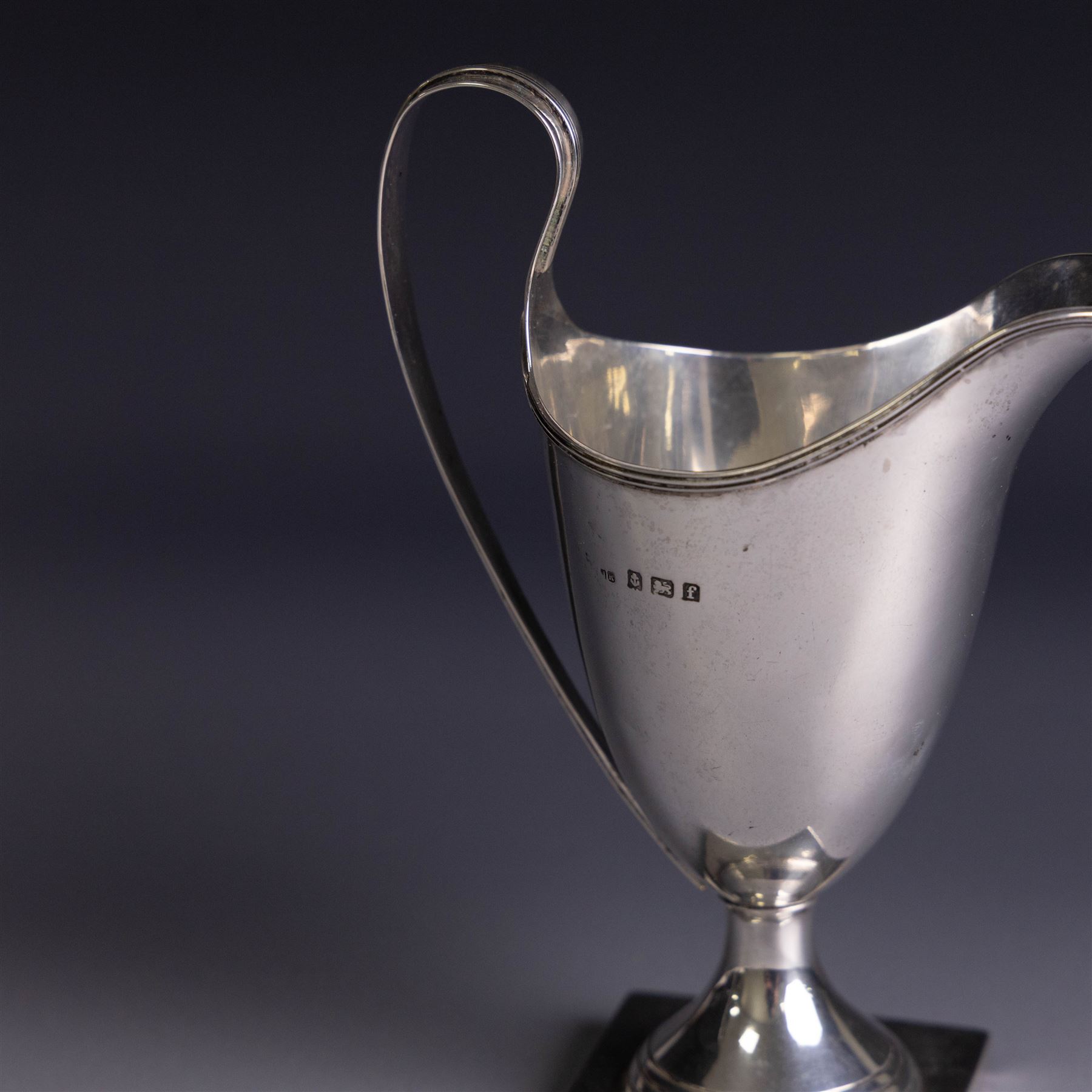 Edwardian silver helmet shaped cream jug, upon a square base, hallmarked John Rose, Birmingham 1905, together with a 1930s silver christening mug with engraved initials to body, hallmarked Aaron Lufkin Dennison, Birmingham 1936, jug including handle H13cm