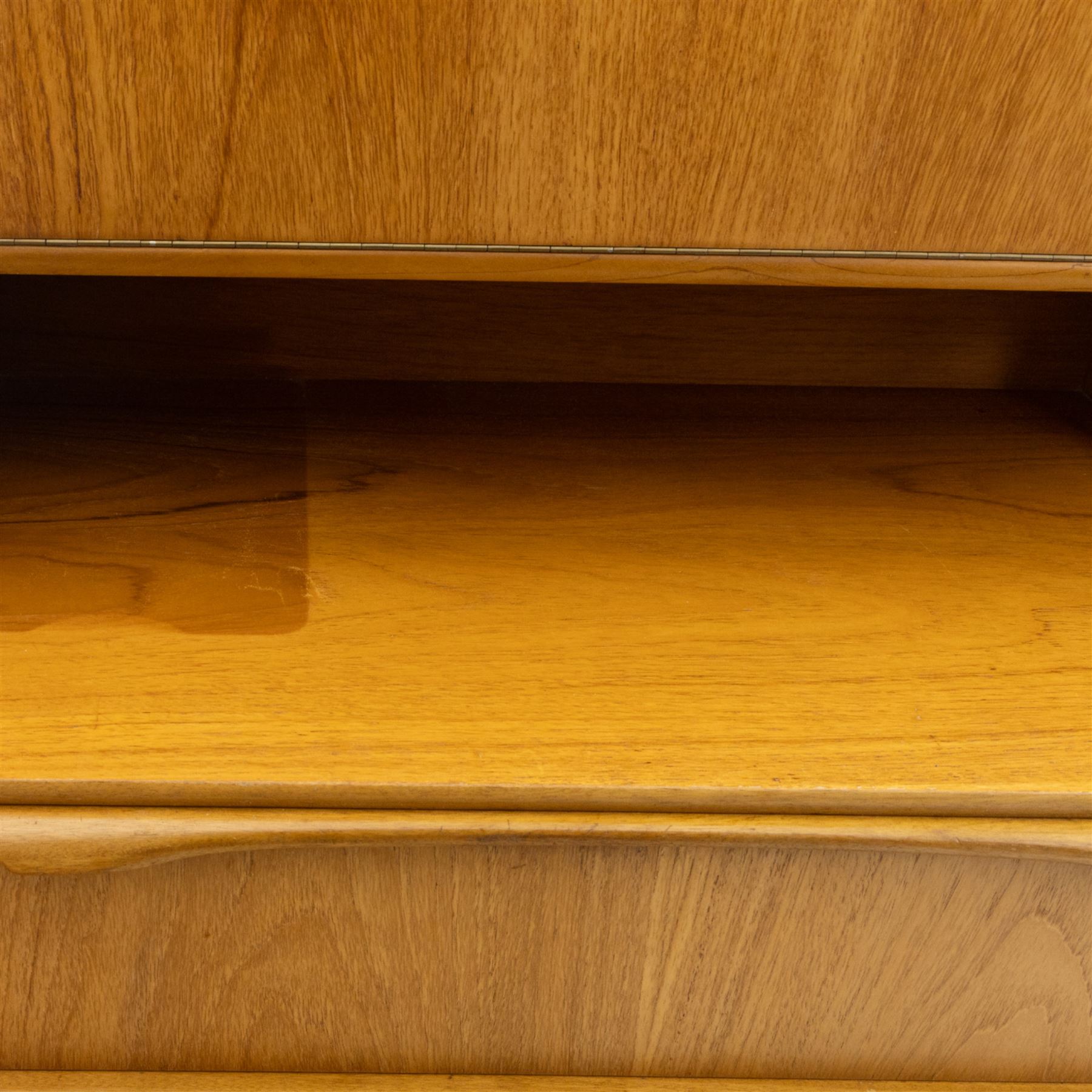 Sutcliffe of Todmorden - Mid 20th century teak highboard, ‘S-Form’ range, the upper section with glazed and panelled sliding doors above open shelving, over a base fitted with twin drawers and cupboards, all with moulded recessed handles, on shaped tapering supports, reflecting the sleek organic styling characteristic of 1960s British modern furniture design