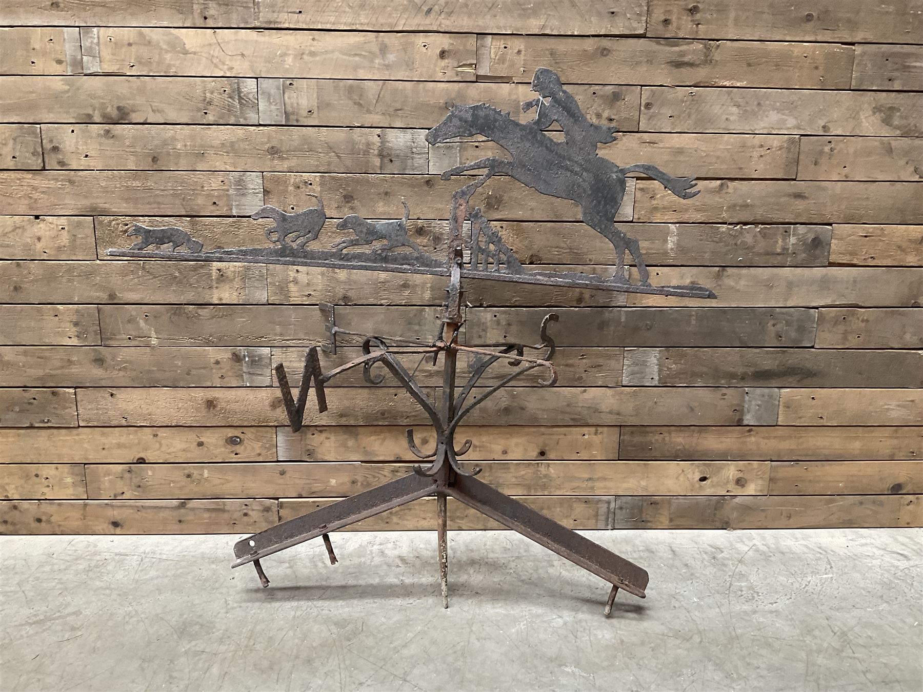 Black painted wrought iron weather-vane depicting hunting scene and compass points
