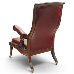 William IV mahogany high-back library reading armchair, arched cresting rail with moulded C-scrolls and bellflowers, the padded arms raised on waisted supports with lappet style carving below scrolled arm terminals, the lower reeded frame raised on splayed supports with brass cups and castors, upholstered in red leather with sprung seat