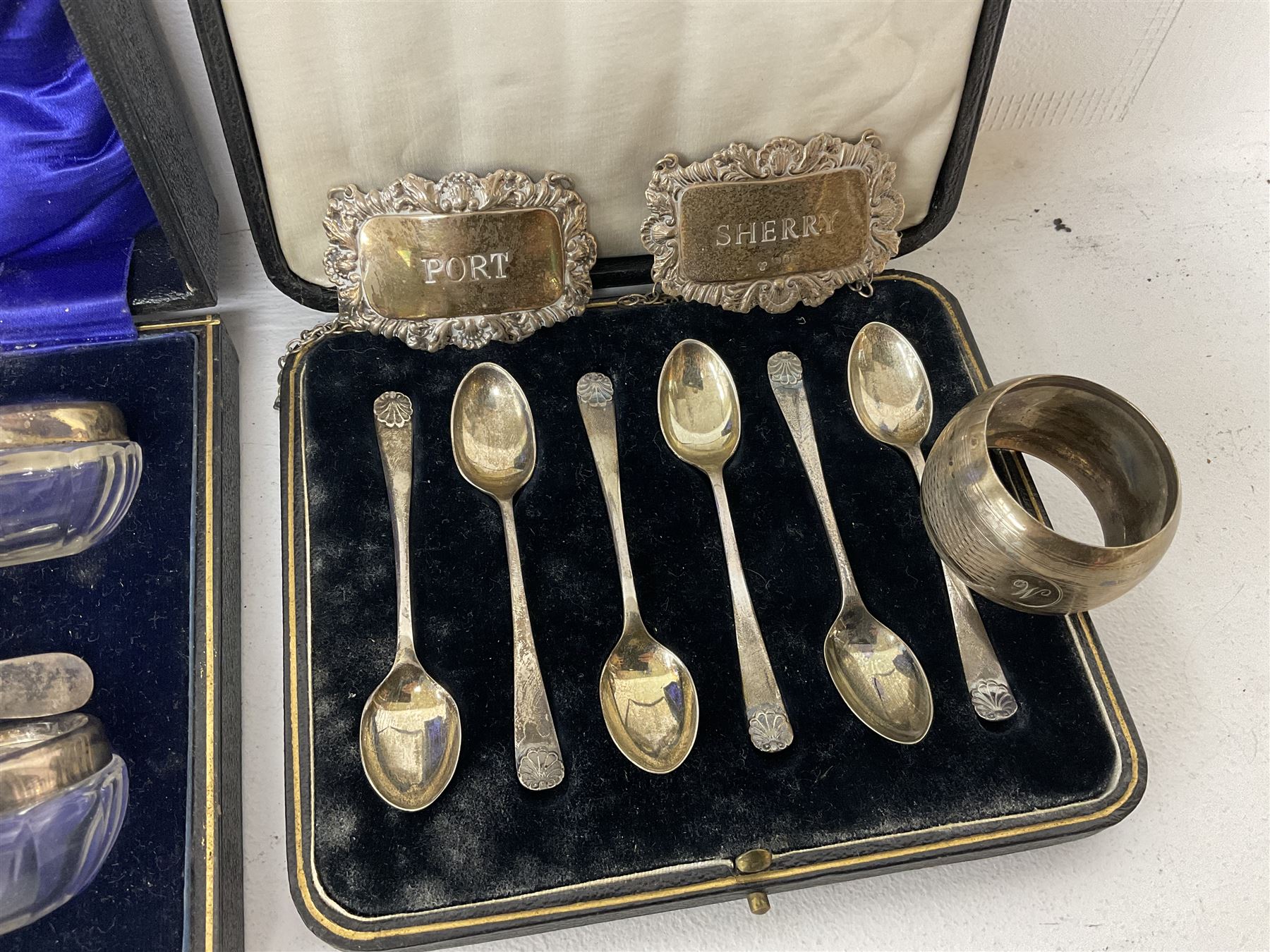 Cased set of six spoons by Cooper Brothers & Sons, two hallmarked silver decanter labels, four silver collared glass salts in box, further silver spoon and napkin ring