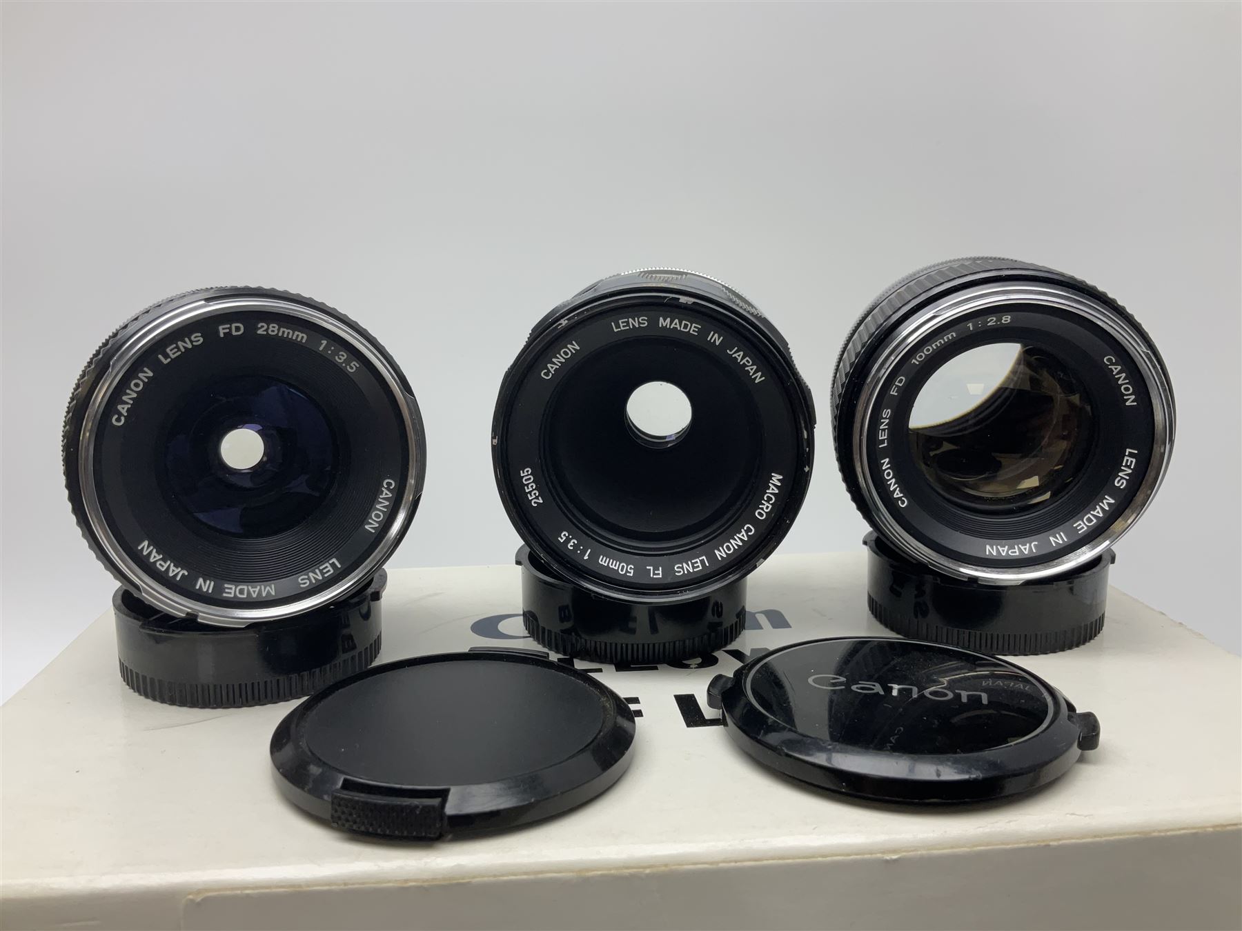 Collection of Canon lenses, to include 'Canon Lens FD 100mm 1:2.8', serial no 12821, 'Canon Lens FD 200mm 1:4' serial no 245313, 'Macro Canon Lens FL 50mm 1:3.5', serial no. 25505, 'Canon Lens FD 135mm 1:3.5 etc, together with other Canon equipment, including Bellows FL, Slide Duplicator etc 
