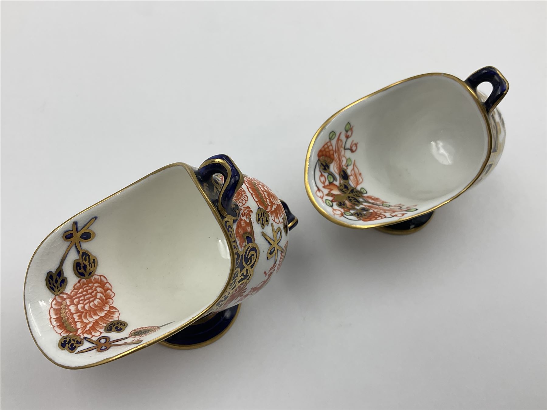 Group of Crown Derby and Royal Crown Derby Imari pattern miniatures, including mid 19th century Stevenson and Hancock cauldron, with painted mark beneath, H5.5cm, a near pair of early Royal Crown Derby scuttles, decorated in the 6299 pattern, each with printed and painted marks beneath including illustration date codes for 1913 and 1922, tallest 6.5cm, and a further early 20th century Royal Crown Derby scuttle, decorated in the 6299 pattern, with printed and painted marks beneath including illustration date code for 1922, H5.5cm, (4)
