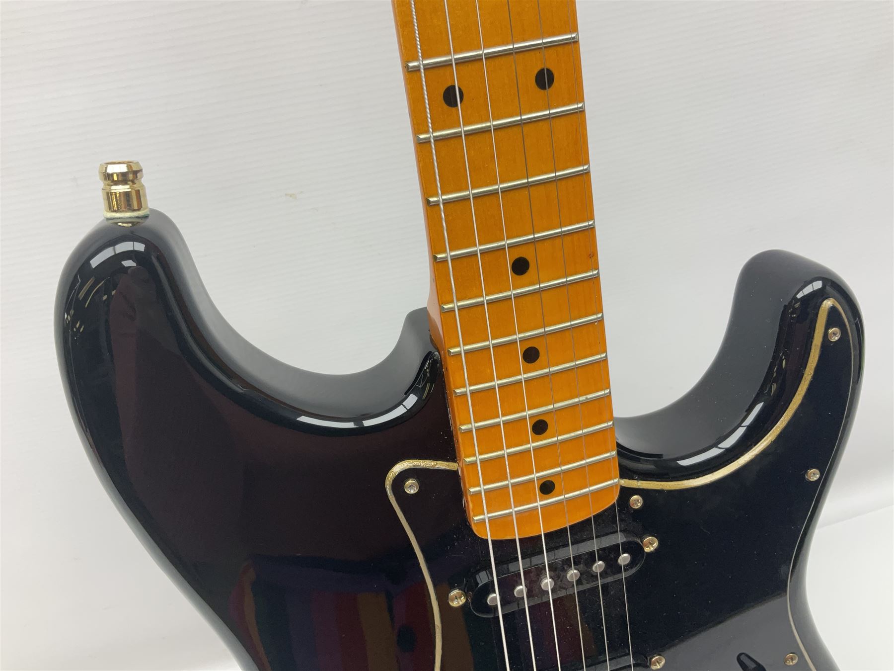 Copy of a Fender Stratocaster electric guitar in black with Wilkinson bridge, lock-in tuners, synchronised tremolo and various patent numbers; L99cm; in hard carrying case with strap and digital tuner