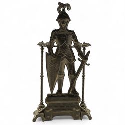 Early 20th century painted cast iron hall stand, formed as a standing armoured figure with red and yellow feathered crest, twin rails and integral drip tray with castellated edge