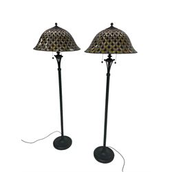 Pair ebonised metal standard lamps, reeded column wit scalloped base, with Tiffany design stained glass bell dome shaped shades