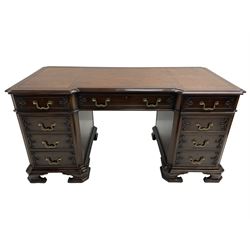 Chippendale design mahogany reverse break-front twin pedestal desk, moulded top with tooled inset leather, fitted with nine cock-beaded drawers mounted with foliate twist carvings, the pedestals with concaved canted uprights corners, lower edge moulding over canted ogee bracket feet with carved detail