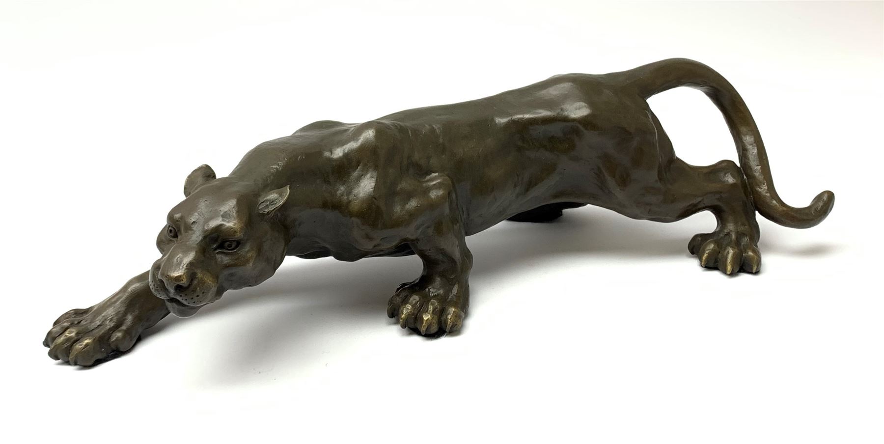A bronze figure, modelled as a cougar in crouching pose, signed Milo and with foundry mark, L40cm.
