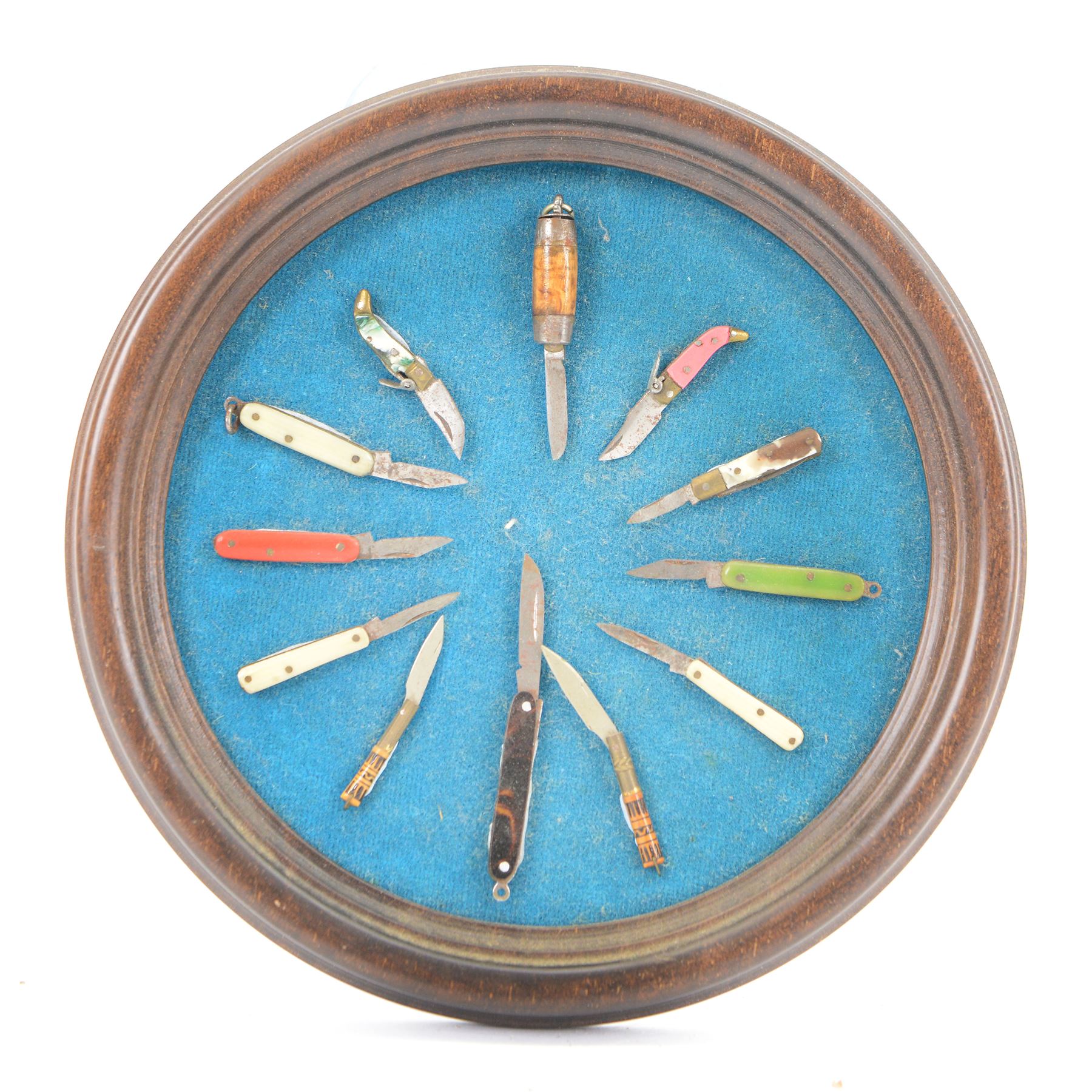 Collection of twelve miniature pen knives, displayed in an circular frame  
