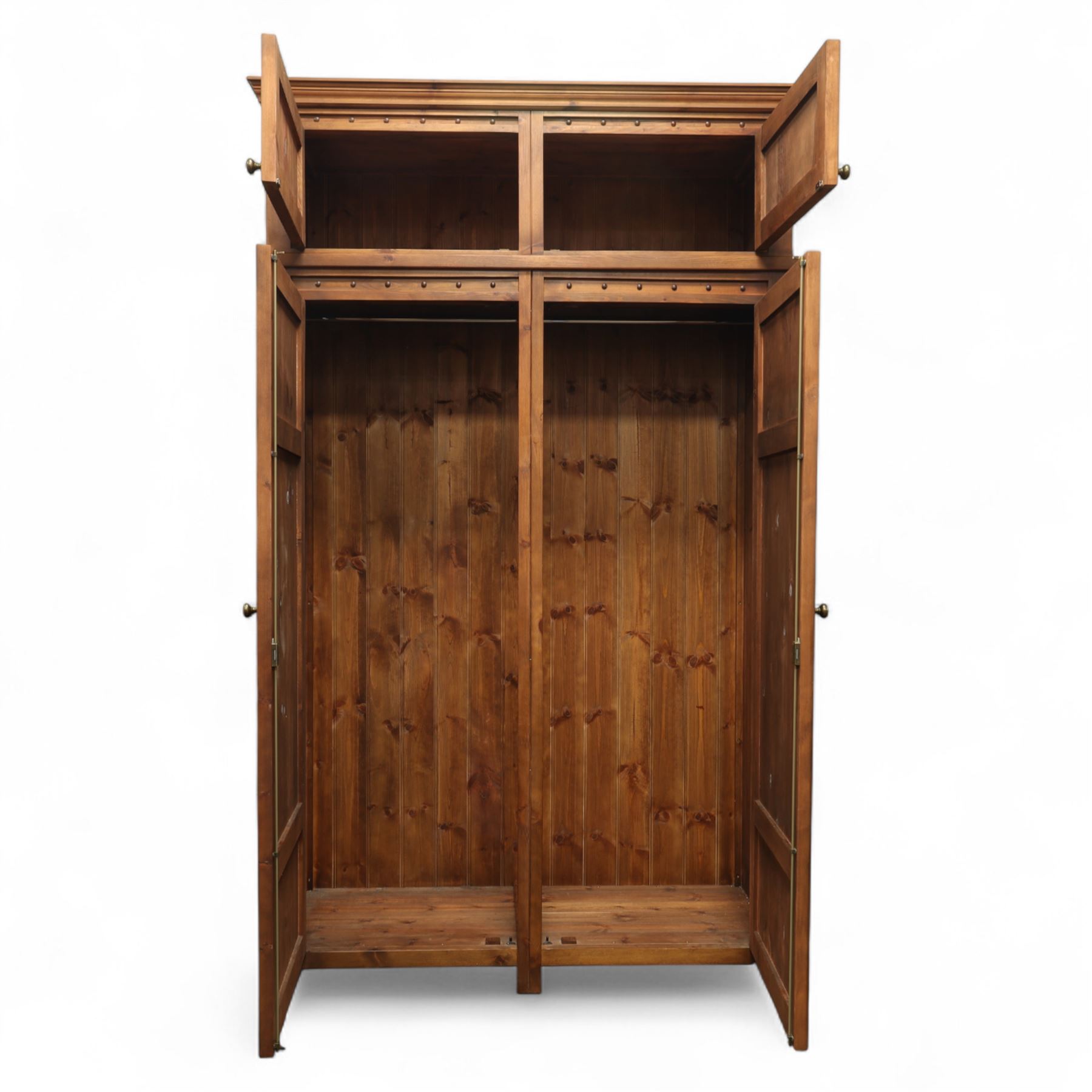 Traditional design contemporary dark stained pine double wardrobe with top box, twin three panelled door with wooden studded frieze, enclosing a single metal rail, with a top box above with brass handles