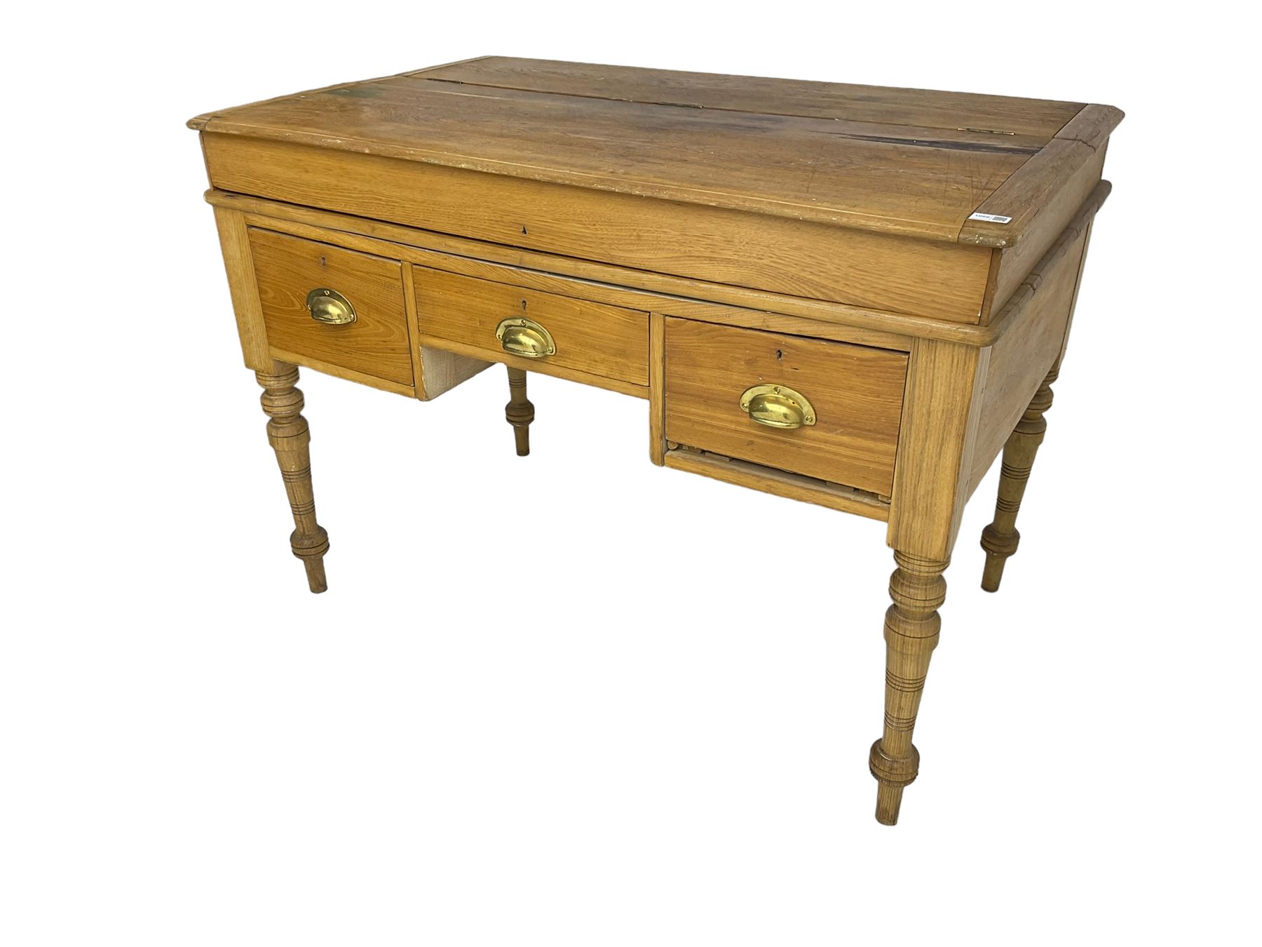 Early 20th century light oak kneehole desk, rectangular hinged top, fitted with frieze drawer flanked by two deep drawers, raised on ring turned supports