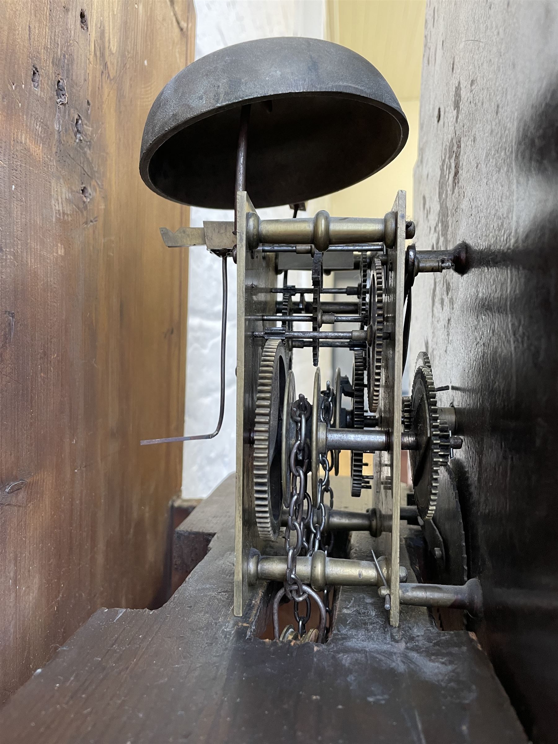 Thirty-hour oak cased longcase clock by  William Bancroft of Scarborough circa 1830, with a swan’s neck pediment, brass patera and three brass spire and ball finials, stepped break arch hood door flanked by plain pillars with brass capitals, trunk with a full length door and curved arch top, on a plain square plinth with bracket feet, painted break arch dial with roman numerals and quarter hour Arabic’s, date recorder (anti clockwise) and matching brass hands, arch painted with a rural scene depicting a ruined tower and cottage with depictions of flowers to the spandrels, dial pinned directly to a chain driven countwheel striking movement, striking the hours on a bell. With weight and pendulum. The Bancroft family were prodigious Scarborough clockmakers during the 18th and 19th century, William Bancroft is recorded as working in Newborough Street from 1820 onwards. 



