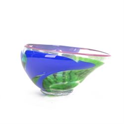 Jane Charles (British Contemporary): freeform studio glass bowl, with green, blue and purple flowing decoration, upon a textured circular foot, H16.5cm, D30cm