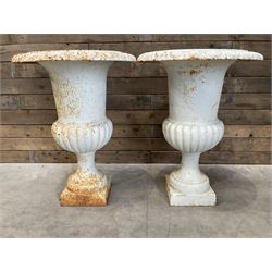 Pair of large Victorian design white painted cast iron campana shaped garden urns, egg and dart rim over a gadrooned underlobe, tapering column on square plinth base