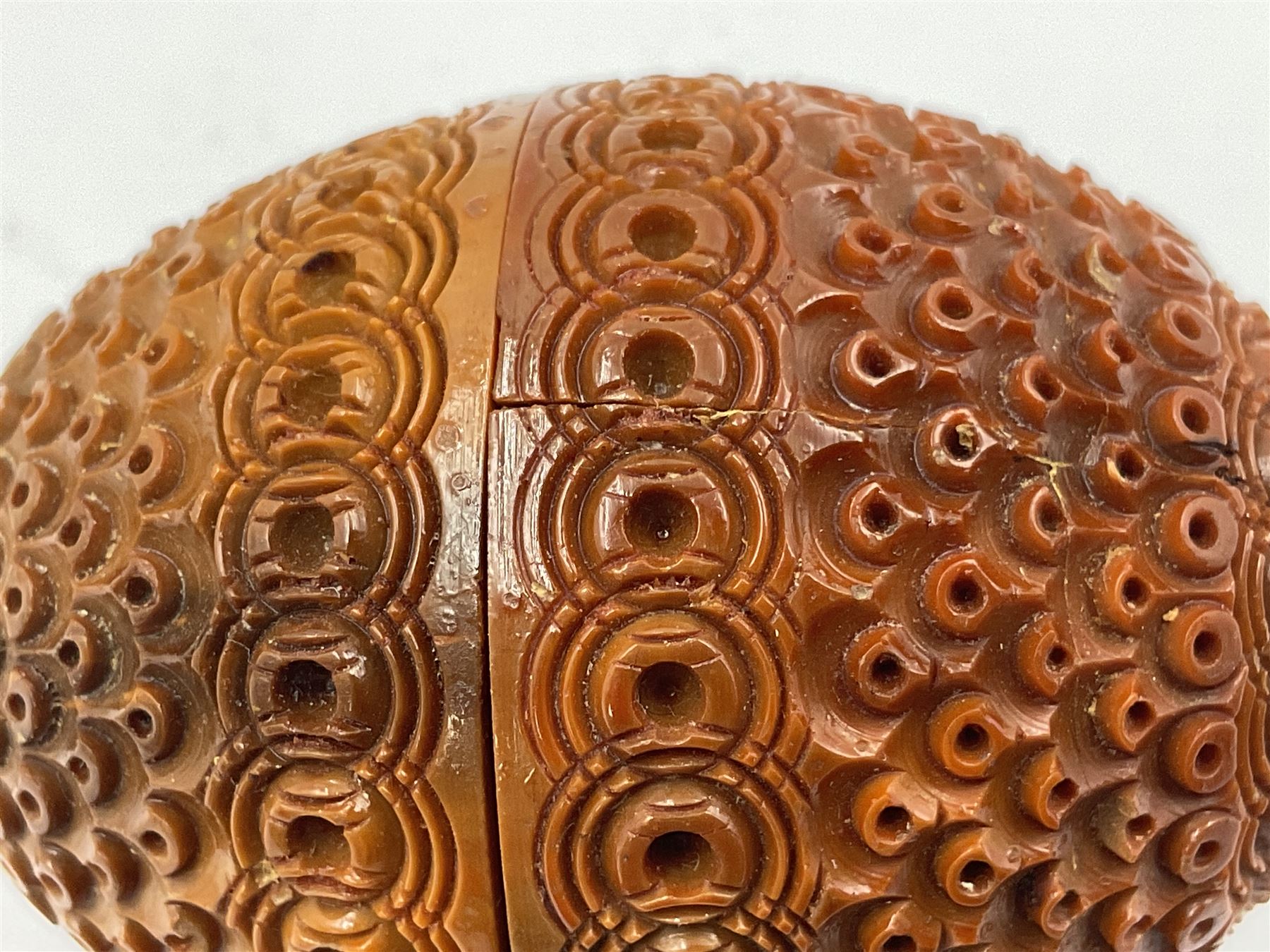 Three 19th century coquilla nut pomanders or flea catchers, two of egg shaped form and the third of barrel from with carved and pierced decoration and screw threaded join, largest H8cm