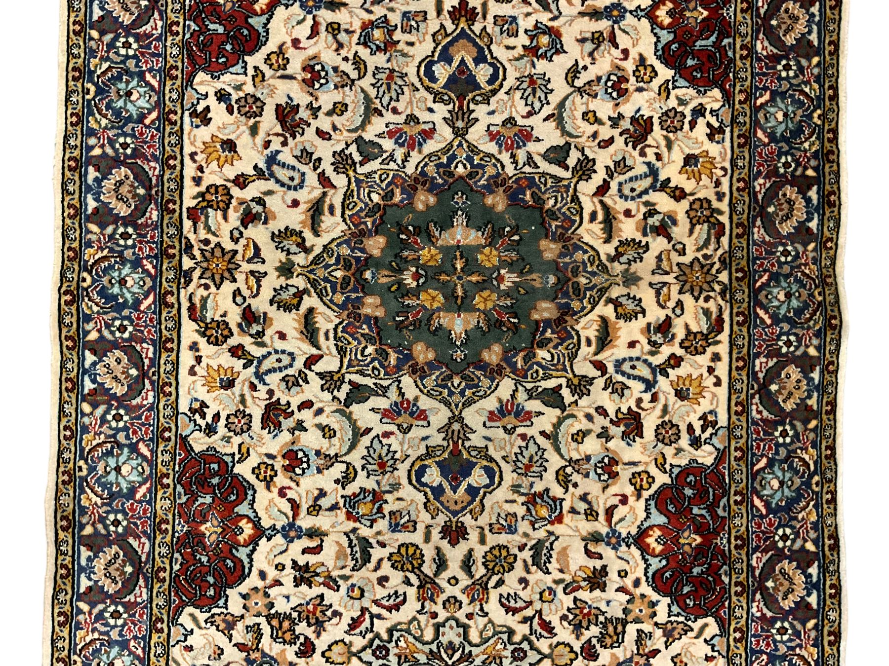 Persian ivory ground rug, central green floral pole medallion within a field decorated by scrolling foliate patterns, the guarded border with repeating palmettes and floral designs