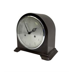 Enfield- English 1950's 8-day mantle clock in a round topped brown Bakelite case on splayed feet, with a glazed chrome bezel and silvered dial with Arabic numerals and original pierced hands, twin train spring driven movement, sounding the hours and half-hours on a coiled gong. With pendulum & key.  
