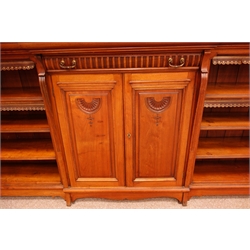  Large late Victorian walnut breakfront low bookcase, raised shelved back with scroll cresting above a single lobed drawer stamped Lamb Manchester, two central panel doors enclosed by reeded scroll columns, shaped apron and feet, W294cm, H177cm, D43cm  