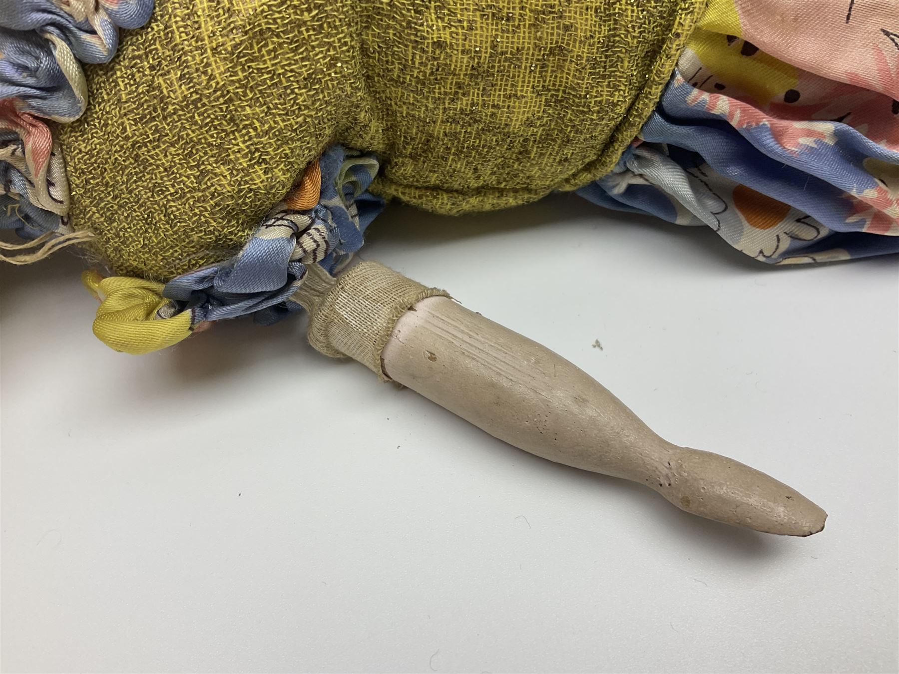 Victorian large wax over composition Pumpkin head doll, with inset dark glass eyes, moulded blonde hair in curls, stuffed body with carved and painted wooden limbs, grey painted boots, floral satin dress with netting underclothes H61cm