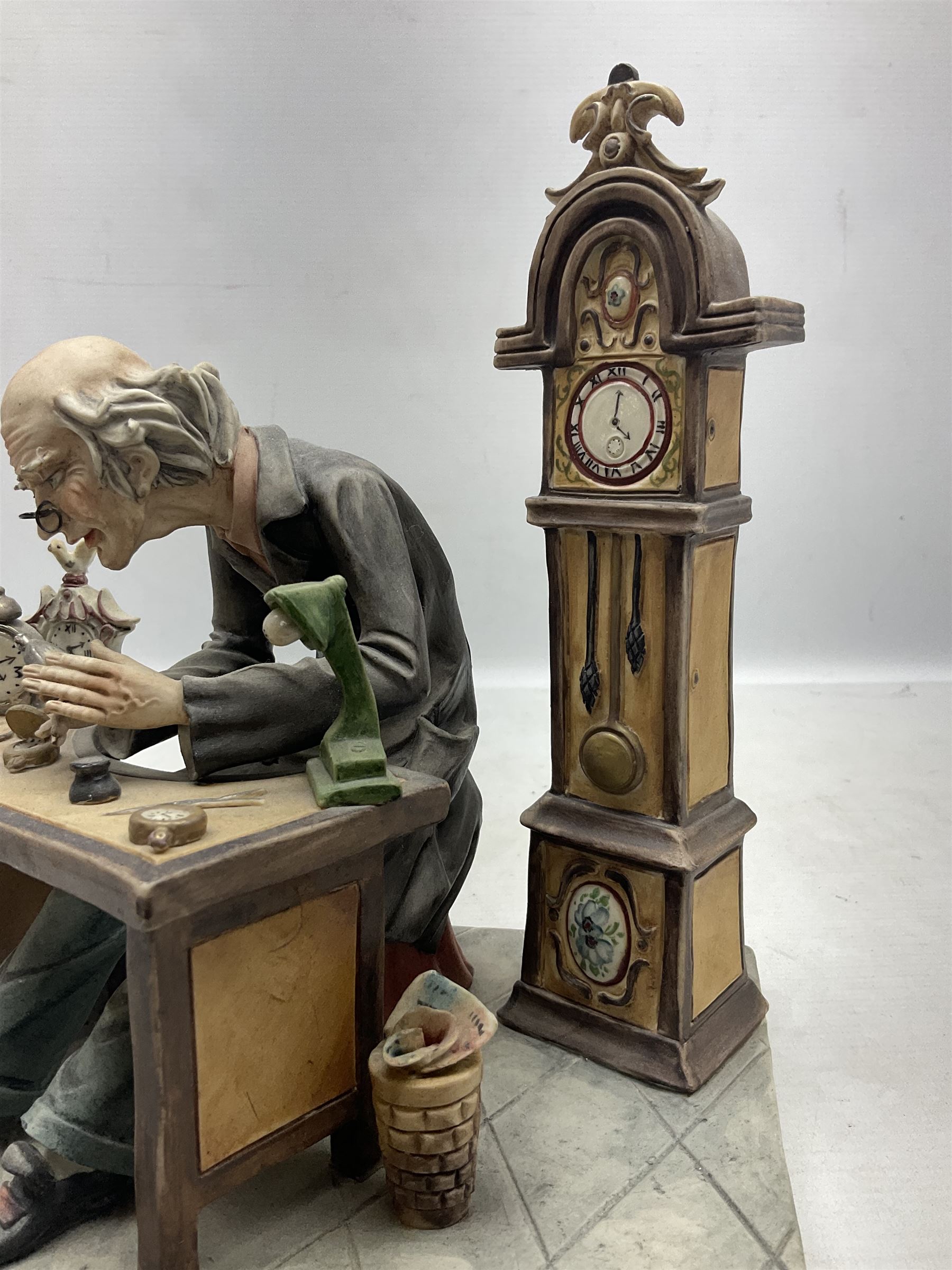 Two Capodimonte figures, comprising The Watchmaker by Curiase and Tramp Seated on a Bench, created by D.Bonalberti, tallest example H24cm