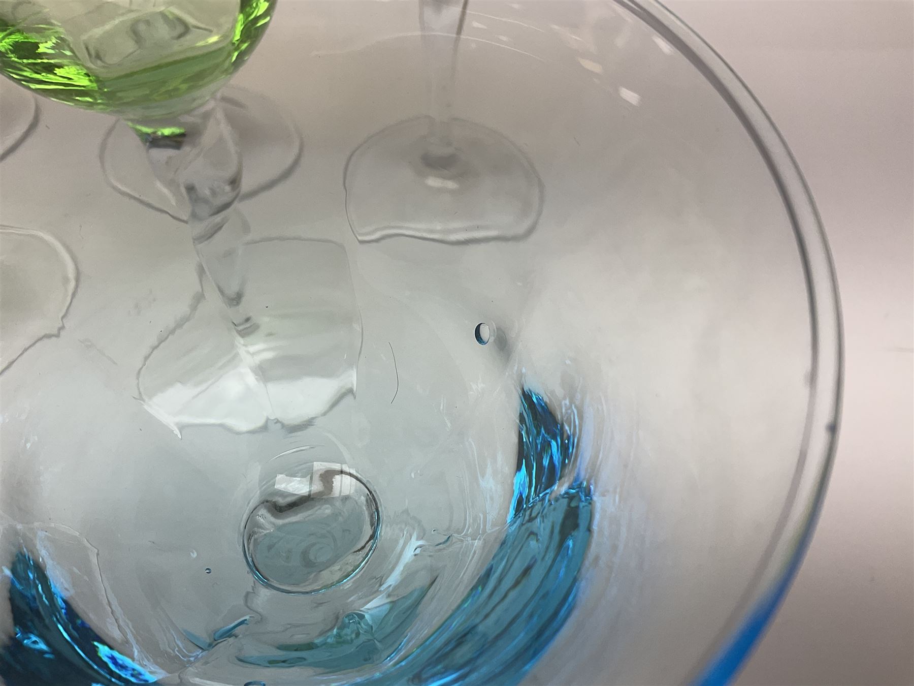 Ten coloured Adriana wine glasses by Abigails, to include blue, green, pink and yellow examples, each with part faceted bowl and twist stems, together with two similar orange examples with pulled stems, H24cm