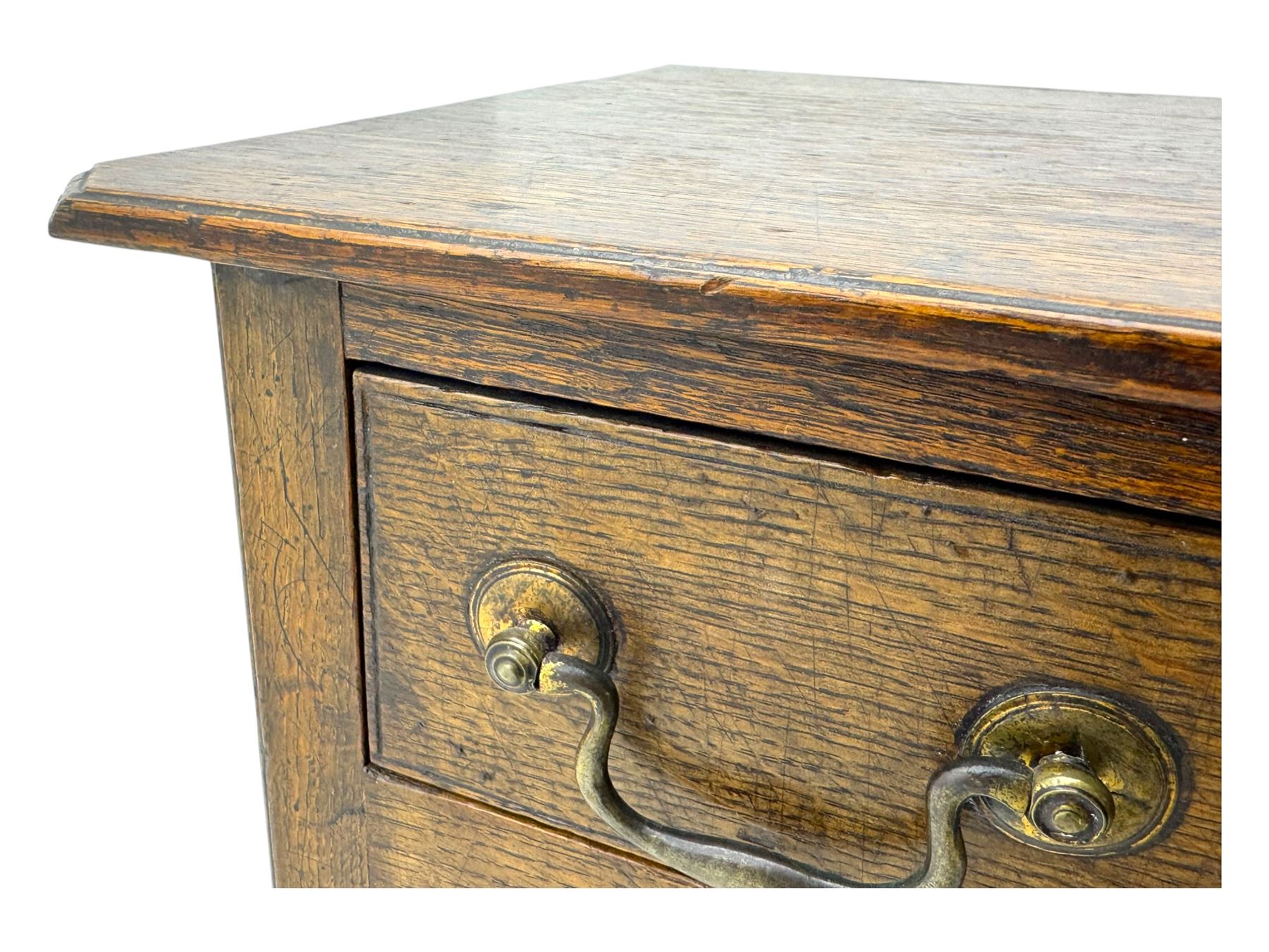 18th century oak lowboy, rectangular moulded top over three frieze drawers with brass swing handles, scalloped apron, on slender square section supports