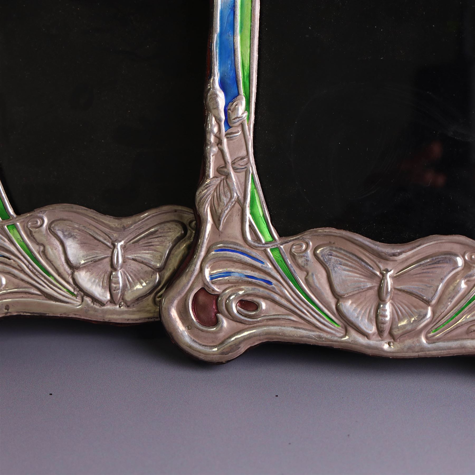 Pair of silver mounted Art Nouveau style photograph frames, with enamel butterfly and floral decoration, with wooden easel stands verso, stamped Sterling, H21cm