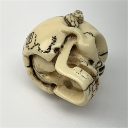 Japanese Meiji carved ivory netsuke, modelled as a skull, the top carved with two toads, and script and signature to reverse, L5cm, H4cm   